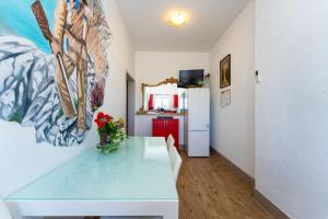 a room with a white table and a refrigerator at Apartmani Tinka in Starigrad