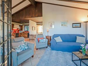 a living room with a blue couch and two chairs at Les Cassis in Nendaz