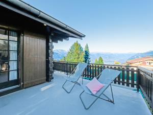two chairs and a pink pillow sitting on a balcony at Les Cassis in Nendaz +27 photos