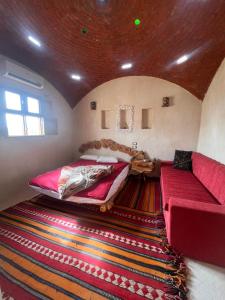 a room with two beds and a couch and a rug at Azru hotel siwa in Siwa