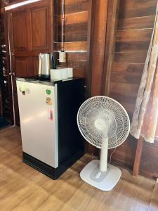 a white fan sitting next to a refrigerator at Kwangpeeb Homestay in Ko Phayam