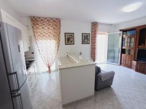 a kitchen and living room with a sink and a couch at Siderea House in Chioggia