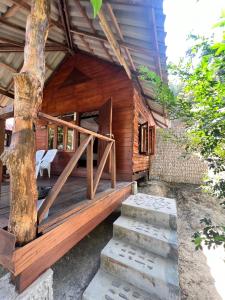 a wooden house with stairs leading to it at Kwangpeeb Homestay in Ko Phayam +10 photos