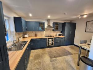 a kitchen with blue cabinets and a sink at The Old Mill - Ripon Centre in Ripon +12 photos