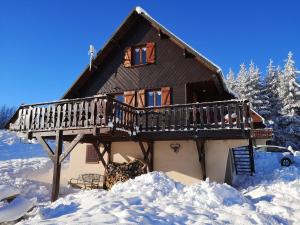 a house with a deck in the snow at chalet besse en chandese in Besse-et-Saint-Anastaise