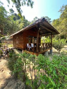 a small wooden hut in a field with trees at Kwangpeeb Homestay in Ko Phayam