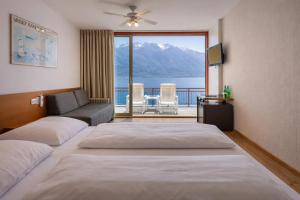 a hotel room with two beds and a balcony at Hotel Lido Lakefront in Limone sul Garda