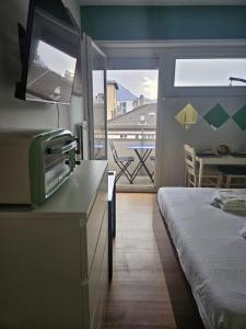 a room with a bed and a kitchen with a balcony at Tropical Lugano in Lugano