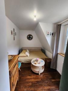 a small room with a bed and a table at Séjour idyllique normand - Appartement cosy à 5 min de la plage - Veules-les-Roses in Veules-les-Roses +9 photos