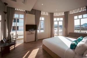a bedroom with a large white bed and windows at GinGin Hotel, Trang Old Town in Trang +25 photos