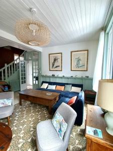a living room with a couch and a table at Le Cinquante-Trois, Maison Normande d'exception pour familles - Côte d'Albâtre in Saint-Valery-en-Caux