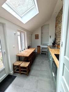 a kitchen with a wooden table and a skylight at Le Cinquante-Trois, Maison Normande d'exception pour familles - Côte d'Albâtre in Saint-Valery-en-Caux +20 photos
