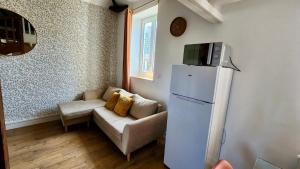 a living room with a couch and a refrigerator at L'estacade in Veules-les-Roses