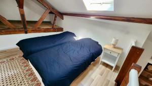 a bedroom with a blue bed and a night stand at L'estacade in Veules-les-Roses
