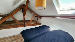 a bedroom with a blue bed in a attic at L'estacade in Veules-les-Roses +4 photos