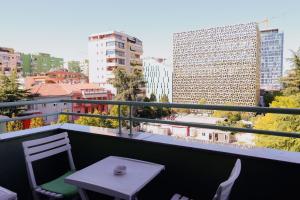 a table and chairs on a balcony with a view of a city at Grand Hotel & Spa Tirana in Tirana