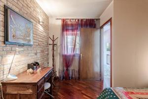 a bedroom with a wooden desk and a brick wall at La tua casa meravigliosa con giardino in Fontanafredda