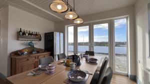 a dining room with a table and a large window at Doonloughan View, Ballyconneely in Ballyconneely