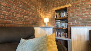 a living room with a brick wall and a couch at Doonloughan View, Ballyconneely in Ballyconneely