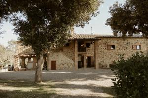 an old stone building with a tree in front of it at Il Paliarete in Orvieto