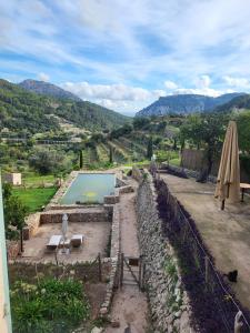 a villa with a swimming pool and an umbrella at HOTEL CA'N UETAM in Valldemossa
