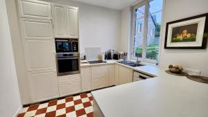 a kitchen with white cabinets and a large window at Villa Tournevent - Villa d'exception avec vue Mer - Veules-les-Roses in Veules-les-Roses +16 photos