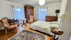 a bedroom with a bed and a table and chairs at Villa Tournevent - Villa d'exception avec vue Mer - Veules-les-Roses in Veules-les-Roses