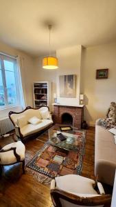 a living room with a couch and a fireplace at Villa Tournevent - Villa d'exception avec vue Mer - Veules-les-Roses in Veules-les-Roses