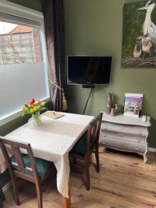 a dining room table with two chairs and a television at t Dinxken in Dinxperlo