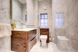 a bathroom with a sink and a toilet and a mirror at London Central Residence in London +35 photos