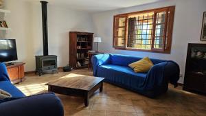 a living room with a blue couch and a fireplace at Ca Na Carme (Alaronera) in Alaró