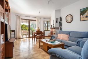 a living room with a blue couch and a table at La Encina in Port d'Alcudia