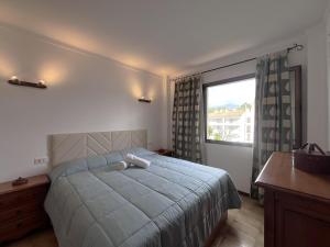 a bedroom with a bed and a large window at La Encina in Port d'Alcudia