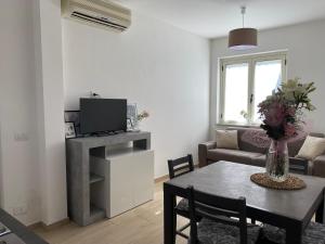 a living room with a table and a tv at Apartmán Sole Vita u moře in Isca Marina
