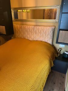 an orange bed in a room with a mirror at t Dinxken in Dinxperlo