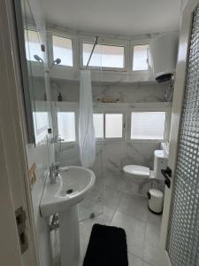 a white bathroom with a sink and a toilet at Babrabat in Rabat +10 photos