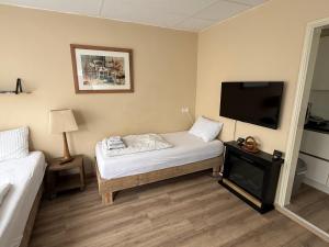 a room with a bed and a flat screen tv at Studio Huzur in Deventer