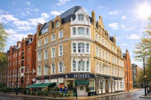 a large brick building with a hotel on a street at City London Hotel in London
