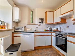 a kitchen with white cabinets and a stove top oven at 2 Bed in Dorchester oc-92416 in Frome Vauchurch