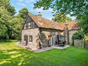 an old stone house with a table and an umbrella at 2 Bed in Dorchester oc-92416 in Frome Vauchurch