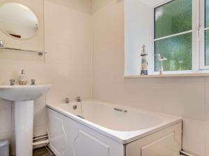 a white bathroom with a tub and a sink at 4 Bed in Dorchester oc-92413 in Frome Vauchurch +20 photos