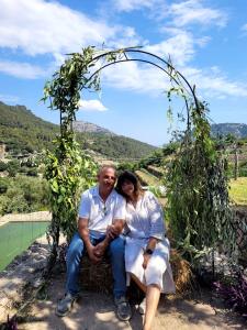 a man and a woman sitting under an arch at HOTEL CA'N UETAM in Valldemossa +1 photo