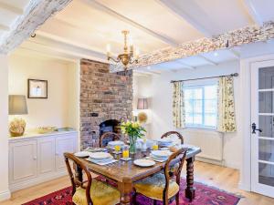 a dining room with a table and a fireplace at 2 Bed in Driffield oc-75583 in Lund