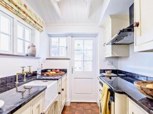 a kitchen with white cabinets and black counter tops at 2 Bed in Driffield oc-75583 in Lund +15 photos