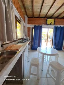 a kitchen with a table and two stools in it at Punta Pacífico Bungalows Máncora in Máncora