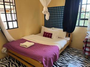 a bed with two towels on it in a bedroom at Mara oasis in Mara Simba