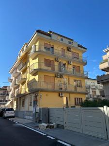 a yellow building with a fence in front of it at Siderea House in Chioggia