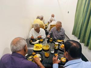 a group of men sitting at a table eating food at Nakshatra in Kovalam