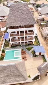 an aerial view of a large white building with a swimming pool at Jamaica House in Nungwi