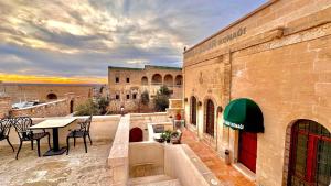 a balcony with a table and chairs and a building at Seyr-i asur in Midyat